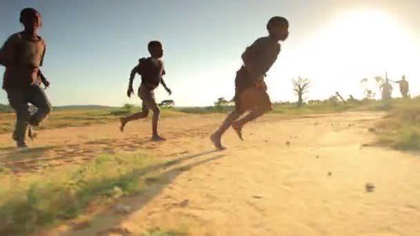 Niños jugando al fútbol en los campos de Kenia, África . — Vídeos de Stock