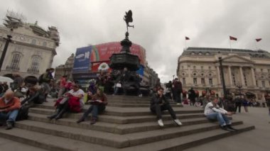 öğrenciler Londra'daki Eros heykelinin merdivenlerinde
