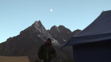 Sabah bir grup çadırın yanında bir adam.