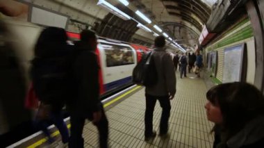 Londra metro istasyonuna tüpte yanında yürüyen insanlar
