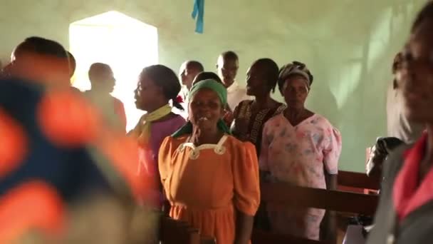İnsanlar Kenya, Afrika'da ibadet sırasında banklar arasında ve koridorda şarkı ve dans. — Stok video