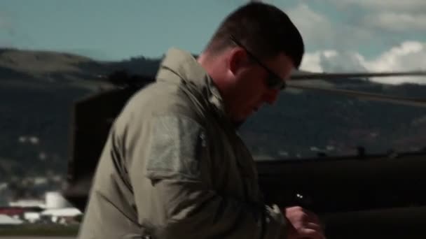Солдат смотрит на часы, когда стоит в зоне высадки. — стоковое видео