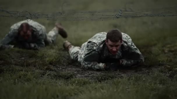 Soldaten kruipen onder draad aan een hindernissenparcours — Stockvideo