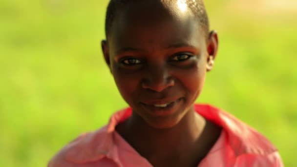 Keniaanse meisje lachen en glimlachen in de buurt van een boom — Stockvideo