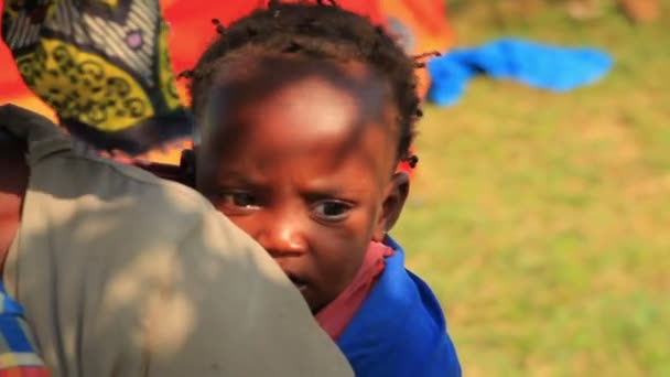 Baby on mother's back looking into the camera in Kenya. — Stock Video