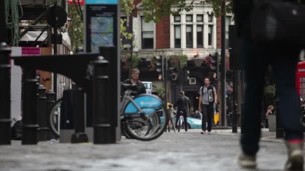 Люди ходят по тротуарам на площади Сохо — стоковое видео