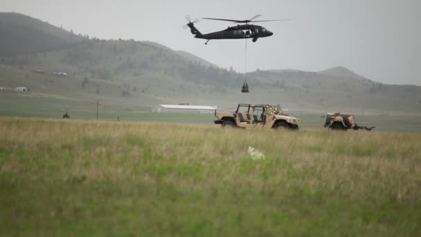 Helikopter dropping lading in veld — Stockvideo