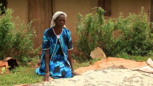 Nainen polvistuu peiton viereen ja levittää tavaraa sen päälle Keniassa, Afrikassa — kuvapankkivideo