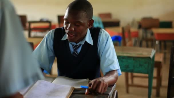 一人の学生がケニアでクラスで別の支援. — ストック動画