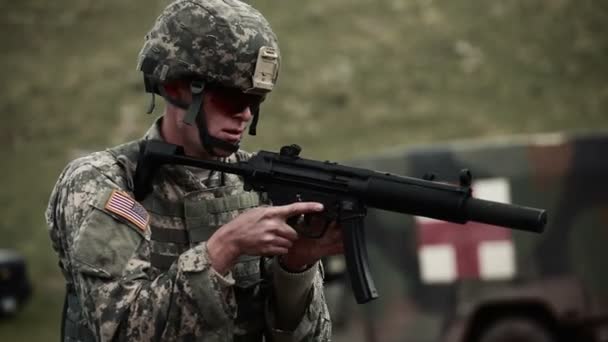 Soldaat in een helm en zonnebril schieten een Mp5 — Stockvideo