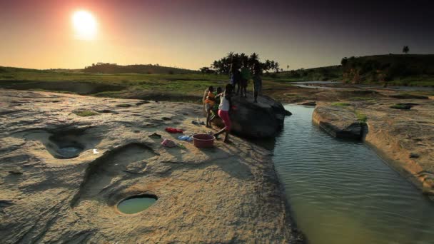 Vissa barn tvätta kläder i en flod i Kenya vid solnedgången. — Stockvideo