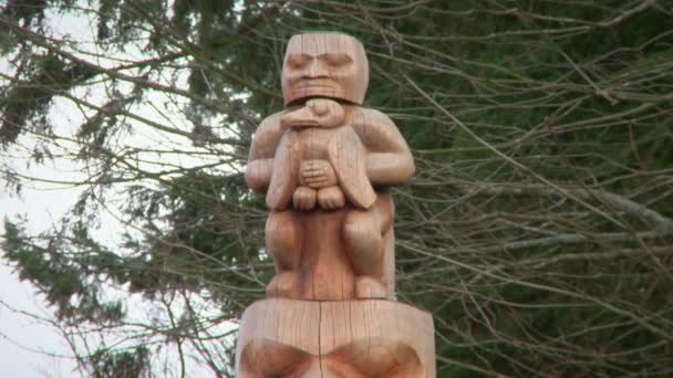 Close up of wooden figure atop a First Nations totem pole — Stock Video