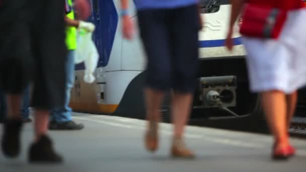 Mensen wandelen langs platform zoals trein trekt en stopt — Stockvideo
