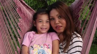 kadın ve çocuk pembe bir hamakta gülümseyen