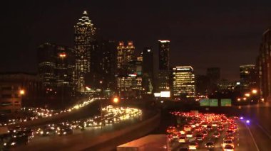 traffic flowing below the lit up Atlanta Skyline.