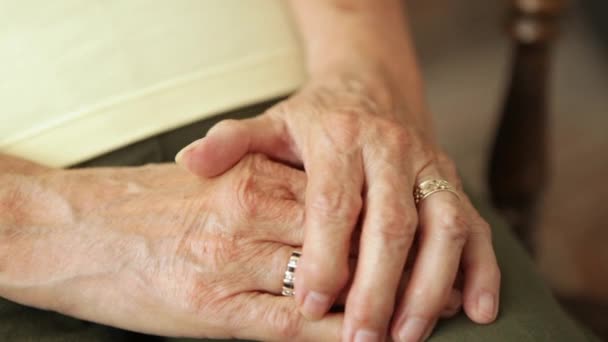 Un primo piano di una donna anziana che si tiene per mano . — Video Stock
