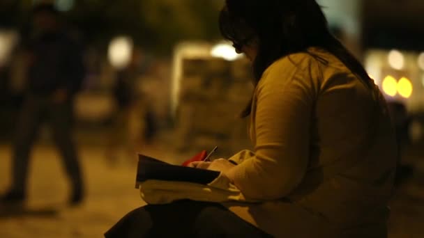 Статический вид человека, сидящего на скамейке и пишущего книгу . — стоковое видео