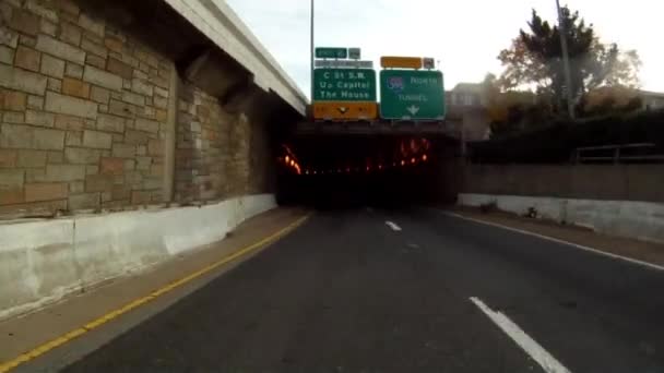 Una toma de mano de conducir a través de un túnel iluminado en Washington DC durante el día . — Vídeos de Stock