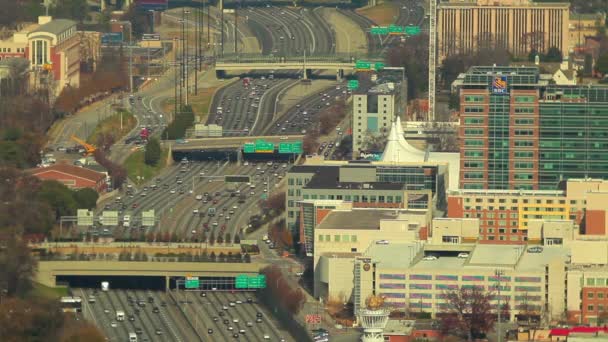 Un plan statique et large de voitures circulant sur l'autoroute avec de nombreux bâtiments de la ville vus de chaque côté . — Video