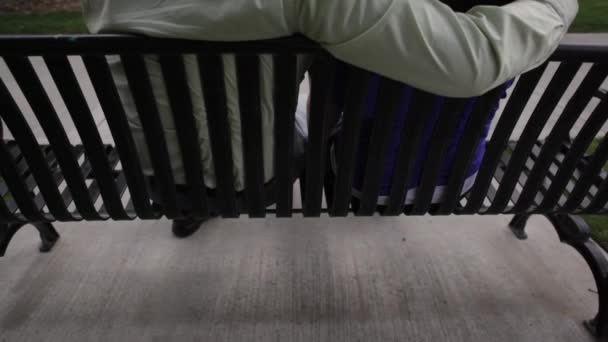 Un colpo di coppia su una panchina in una giornata nuvolosa . — Video Stock