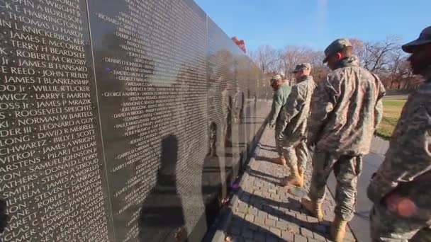 Un disparo estático de la espalda de un grupo de soldados caminando por el Monumento a la Guerra de Vietnam . — Vídeos de Stock