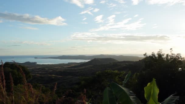 Widok ze szczytu wzgórza z widokiem na krajobraz w kierunku oceanu. — Wideo stockowe