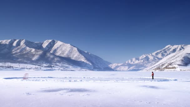 Giocatore di hockey su un lago ghiacciato . — Video Stock