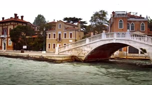 Brygga, båt och byggnader längs en kanal i Venedig — Stockvideo