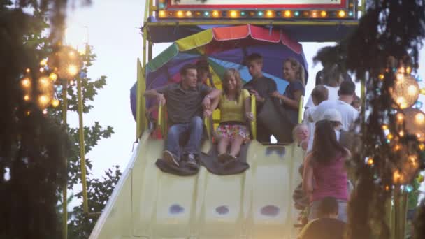 Casal deslizando para baixo um slise em um carnaval . — Vídeo de Stock