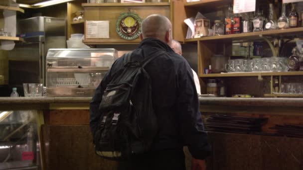 Statische vervolgens panning shot van een man in een Italiaanse café bestellen. — Stockvideo
