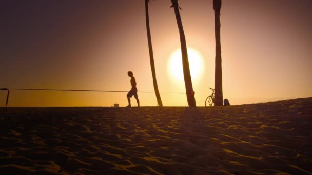 Man wandelen naast slackline op het strand — Stockvideo