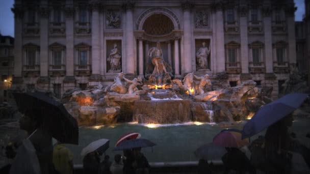 Toeristen bezoeken de Trevi-fontein in de schemering in de regen — Stockvideo