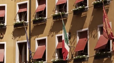 Windows and flags close up on side of building, Venice