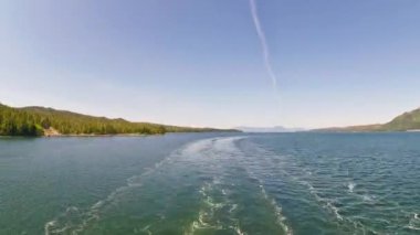 Ketchikan, Alaska yakınlarındaki bir kanala giden bir yolcu gemisinin arkasından hızlandırılmış.