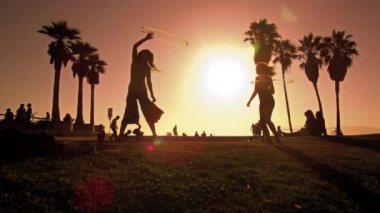 Ağır çekimde lens flare atış Venice Beach, Kaliforniya geziniyor insan filme
