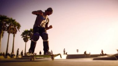 İnsanlar yavaş çekimde Ocean açık Walk yakınındaki Venice Beach California günbatımında tadını çıkarın.  