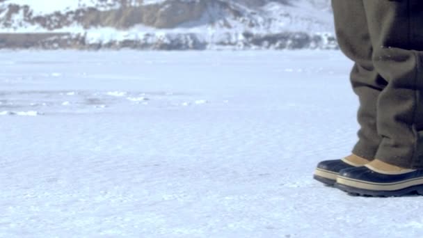Снежные сапоги, идущие по заснеженной земле — стоковое видео