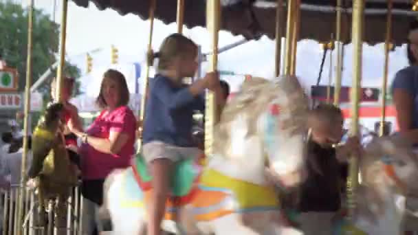 Mensen rijden rond op een merry-go-round op een carnaval — Stockvideo