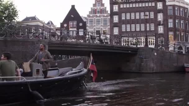 Passerar en bro på en flod i Amsterdam — Stockvideo