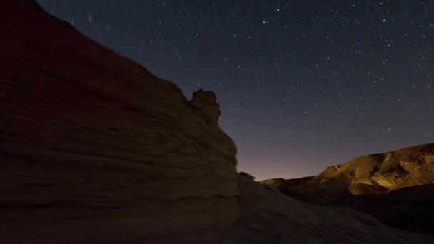 Tracking footage of desert rock formation, and cosmos moving in the sky above — Stock Video