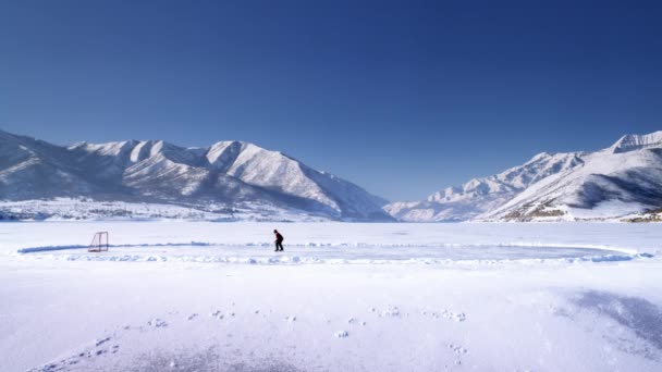 Παγωμένη λίμνη και κάποιος που παίζει χόκεϊ. — Αρχείο Βίντεο