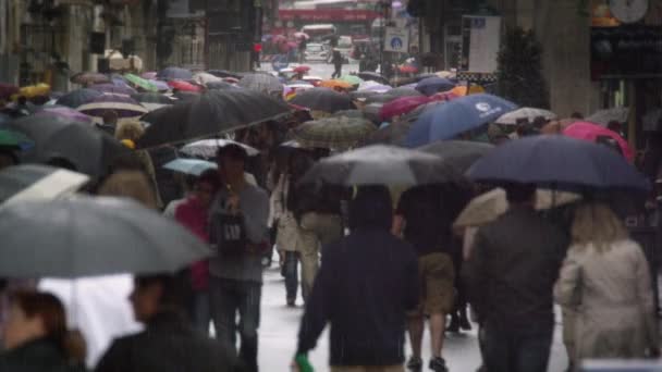 Замедленные съёмки улицы, заполненной людьми, держащими зонты — стоковое видео