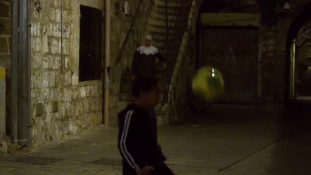 Stock Video Filmagem de um menino fazendo malabarismo com uma bola de futebol à noite filmada em Israel — Vídeo de Stock