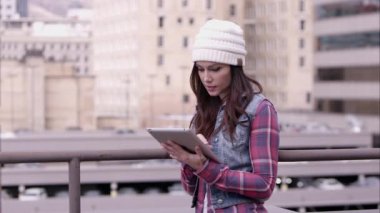  tablet kullanarak şapkalı kadın  