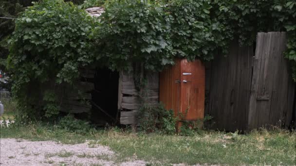 Oude roestige koelbox langs een hek — Stockvideo