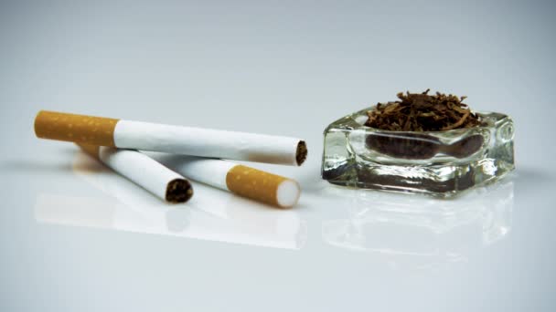 Сигареты и табак в пепельнице — стоковое видео