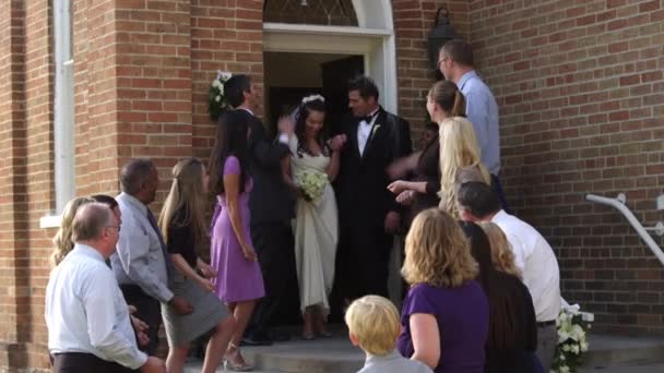 Νύφη και ο γαμπρός το περπάτημα έξω από μια εκκλησία — Αρχείο Βίντεο