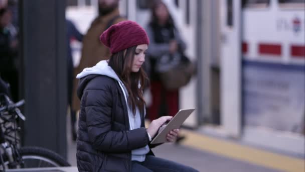 Vrouw met behulp van Tablet PC als mensen om haar heen lopen. — Stockvideo