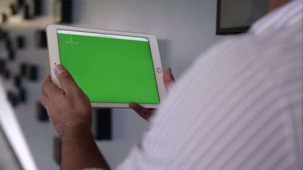 Nézd a vállon, személy, tabletta használata a zöld képernyő. — Stock videók