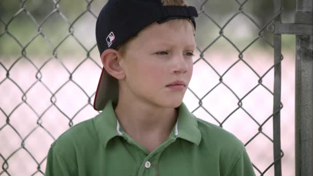 Boy hitting baseball mitt as he turns and smiles. — Stock Video